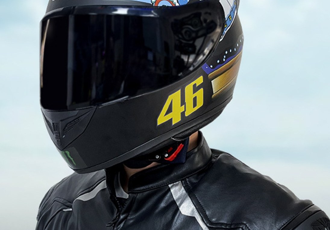 Rider in a black leather jacket wearing a graphic full-face helmet